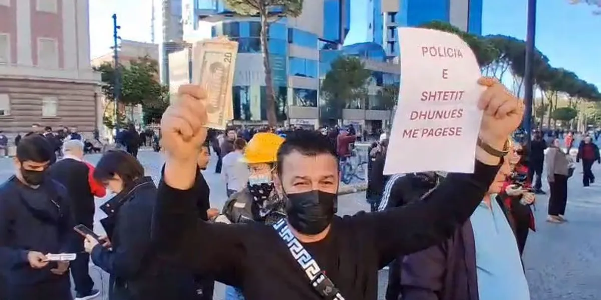  Merrni lekët se u shitët   qytetari i hedh  dollarë  policëve që qëndrojnë para Kryeministrisë